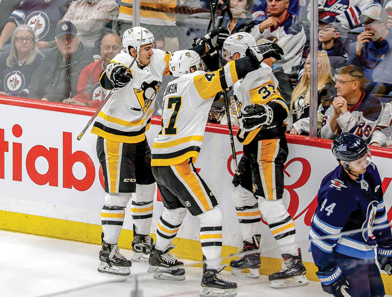 WINNIPEG, MB - OCTOBER 13: Joseph Blandisi #36, Adam Johnson #47 and Sam Lafferty #37 of the Pittsburgh Penguins celebrate a second period goal against the Winnipeg Jets at the Bell MTS Place on October 13, 2019 in Winnipeg, Manitoba, Canada  (Photo by Darcy Finley NHLI via Getty Images)