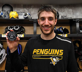 PITTSBURGH, PA - FEBRUARY 18:  Anthony Angello #57 of the Pittsburgh Penguins poses with his first NHL goal puck after a 5-2 win over the Toronto Maple Leafs at PPG PAINTS Arena on February 18, 2020 in Pittsburgh, Pennsylvania  (Photo by Joe Sargent NHLI via Getty Images)