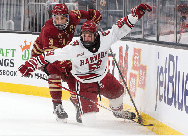 BOSTON, MA - FEBRUARY 14: Zakary Karpa #59 of the Harvard Crimson is checked by Jack St  Ivany #3 of the Boston College Eagles during the first period during NCAA hockey in the consolation game of the annual Beanpot Hockey Tournament at TD Garden on February 14, 2022 in Boston, Massachusetts  (Photo by Rich Gagnon Getty Images)