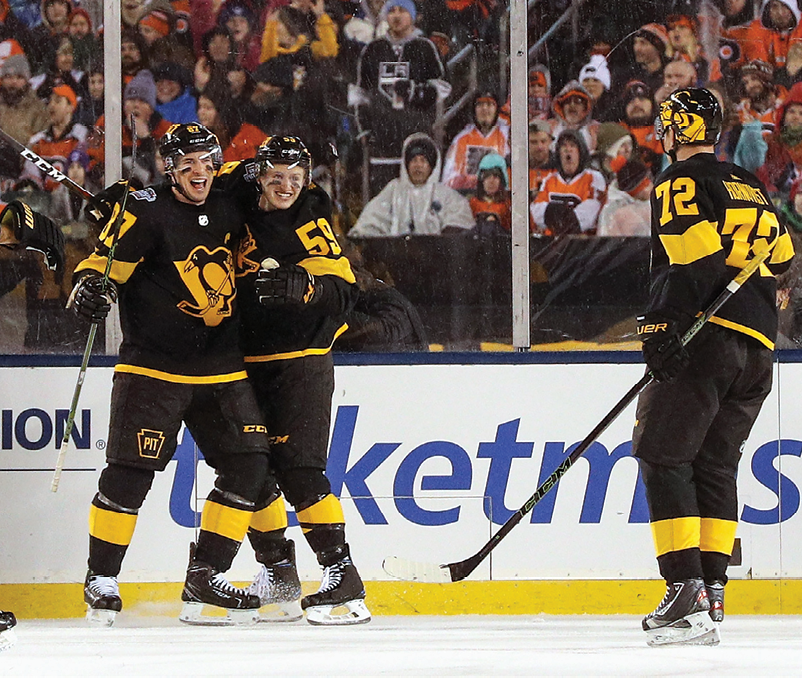PHILADELPHIA, PA - FEBRUARY 23:  (L-R) Sidney Crosby #87, Jake Guentzel #59 and Patric Hornqvist #72 of the Pittsburgh Penguins celebrate Crosby's goal in the first period during the 2019 Coors Light NHL Stadium Series game between the Pittsburgh Penguins and the Philadelphia Flyers at Lincoln Financial Field on February 23, 2019 in Philadelphia, Pennsylvania   (Photo by Dave Sandford NHLI via Getty Images)