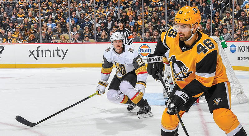 PITTSBURGH, PA - OCTOBER 19:  Zach Aston-Reese #46 of the Pittsburgh Penguins movs the puck in front of Nick Holden #22 of the Vegas Golden Knights at PPG PAINTS Arena on October 19, 2019 in Pittsburgh, Pennsylvania  (Photo by Joe Sargent NHLI via Getty Images)